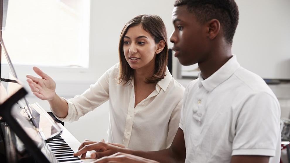 Piano teacher discussing music notes with student